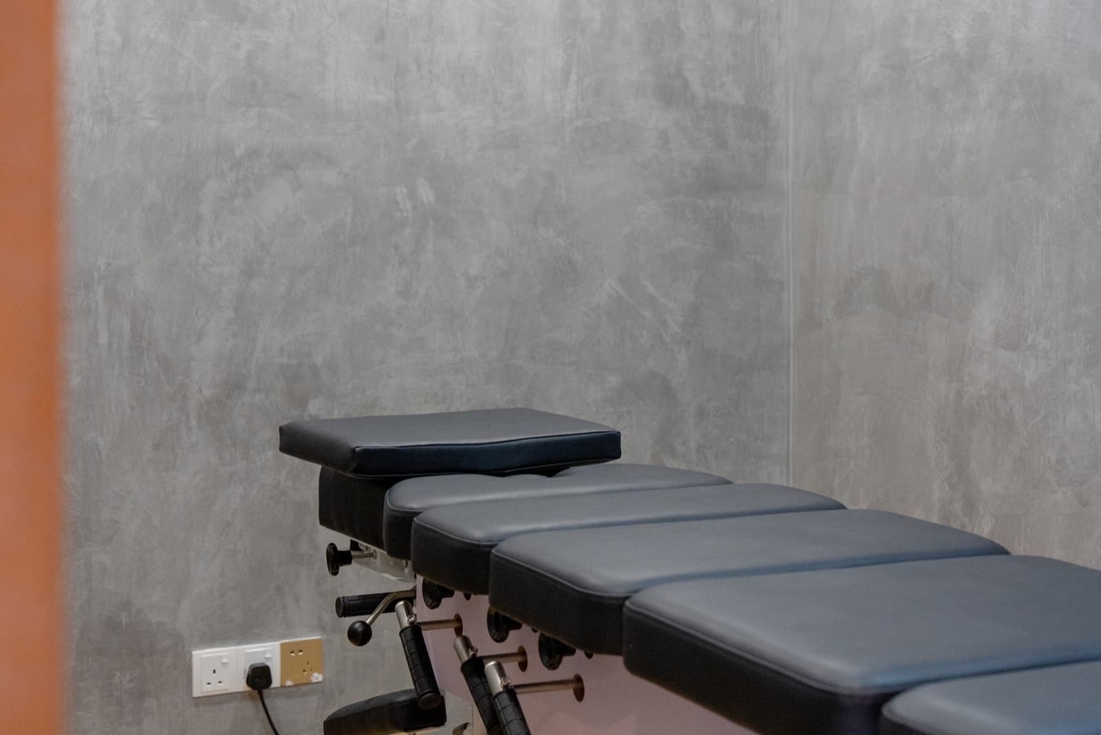 A private therapy room at Savor Wellness, with a treatment table against a concrete wall
