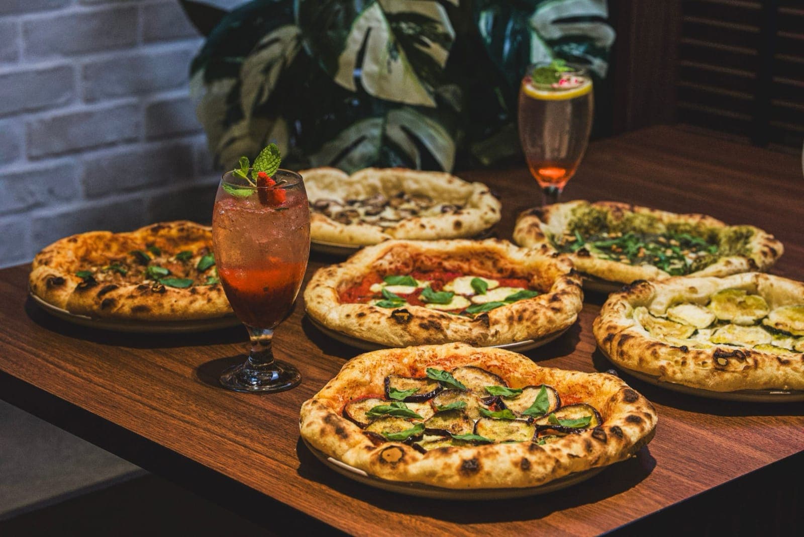 Savor’s six new pizzas on a wooden table